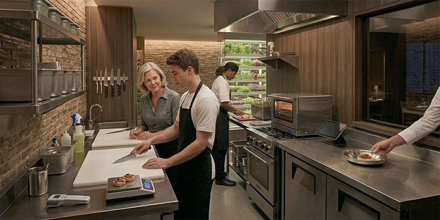 Kokketeam arbeider ved ulike stasjoner i et kompakt restaurantkjøkken
